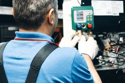 A technician working on air conditioning system maintenance indoors