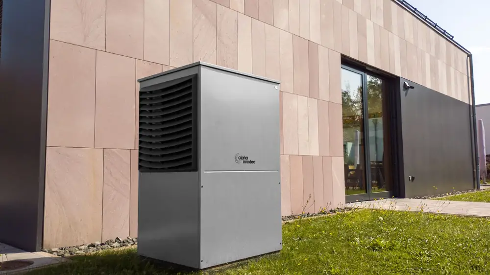 A modern heat pump unit installed outside a contemporary house